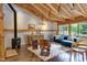 Inviting living room featuring a beamed ceiling, wood burning fireplace, and large picture windows at 1320 Shepherd St, Durham, NC 27707