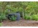 Exterior shot of tanks in the backyard, surrounded by foliage, useful for potential rainwater harvesting or well water storage at 1320 Shepherd St, Durham, NC 27707