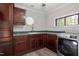 Laundry room with dark cabinets, green countertops, octagon window, and modern appliances at 136 Dixie Ln, Youngsville, NC 27596