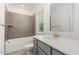 Bathroom with a white vanity, quartz countertop, gray tile backsplash, and a shower/tub combo at 1417 Westmoreland Dr, Raleigh, NC 27612