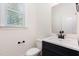 Well-lit half bathroom with a sleek vanity, mirror, and modern fixtures at 1417 Westmoreland Dr, Raleigh, NC 27612
