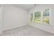 Light-filled bedroom with soft carpet, white walls, and large window with a wooded view at 1417 Westmoreland Dr, Raleigh, NC 27612