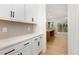 Charming butler pantry featuring white cabinets, stone countertops, and a view into the kitchen at 1417 Westmoreland Dr, Raleigh, NC 27612