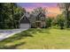 Charming two-story home featuring a lush green lawn under a vibrant sunset sky at 1417 Westmoreland Dr, Raleigh, NC 27612