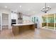 Modern kitchen featuring white cabinets, center island, stainless steel appliances, and a view to the sunroom at 1417 Westmoreland Dr, Raleigh, NC 27612
