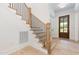 Elegant staircase with hardwood steps and wrought iron railing, complemented by natural light at 1417 Westmoreland Dr, Raleigh, NC 27612