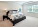 Spacious carpeted bedroom with two windows, recessed lighting and a large bed with side table at 1425 Sierra Glen Cir, Apex, NC 27502