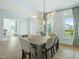 Bright dining room featuring an artistic light fixture, large windows, and hardwood floors at 1425 Sierra Glen Cir, Apex, NC 27502