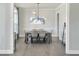 Elegant dining room with modern lighting, a stylish table set for six, and beautiful hardwood flooring at 1425 Sierra Glen Cir, Apex, NC 27502
