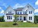 Stunning two-story white home boasting a well-manicured lawn and inviting curb appeal under a bright, partly cloudy sky at 1425 Sierra Glen Cir, Apex, NC 27502