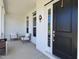 Inviting covered front porch featuring comfortable seating, a stylish exterior light, and an attractive black front door at 1425 Sierra Glen Cir, Apex, NC 27502