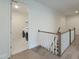 Bright hallway leading to laundry room, hardwood floors, stairs, and neutral paint at 1425 Sierra Glen Cir, Apex, NC 27502