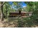 A brick home with red doors is nestled among tall trees providing a private backyard setting at 1500 Lakeside Dr, Garner, NC 27529