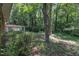 View of a wooded backyard with a home in the background providing a private and natural setting at 1500 Lakeside Dr, Garner, NC 27529