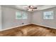Bright bedroom featuring hardwood floors, two windows, and a ceiling fan at 1500 Lakeside Dr, Garner, NC 27529