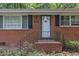 Close-up of the front entrance featuring a brick facade, black shutters, and a charming front door with decorative glass at 1500 Lakeside Dr, Garner, NC 27529