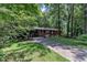 Traditional brick home with a long driveway and lush green lawn, nestled among mature trees providing shade and privacy at 1500 Lakeside Dr, Garner, NC 27529