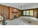 Inviting living room with a brick fireplace, wood paneling, and large windows, perfect for relaxing and entertaining at 1500 Lakeside Dr, Garner, NC 27529