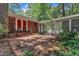 A brick patio with a red door leads to the spacious backyard and attached home at 1500 Lakeside Dr, Garner, NC 27529