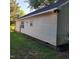 View of the house's side exterior showing the siding and a partial view of the backyard at 1512 E Lane St, Raleigh, NC 27610