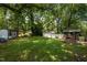 Expansive backyard featuring a storage shed, mature trees, and a brick outdoor cooking area at 1542 W Davis St, Burlington, NC 27215