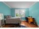Cozy bedroom featuring hardwood floors, a large window with natural light, and neutral blue walls at 1542 W Davis St, Burlington, NC 27215