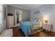 Serene bedroom featuring hardwood floors, blue accents, and a decorative leaf wall design at 1542 W Davis St, Burlington, NC 27215