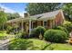 Inviting brick home with a cozy, covered porch and decorative shutters at 1542 W Davis St, Burlington, NC 27215