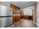 Renovated kitchen features stainless steel refrigerator, granite counters, and wooden cabinetry at 1542 W Davis St, Burlington, NC 27215