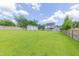 Backyard view of the home and storage shed featuring a large green lawn with privacy fence at 168 Melody Ln, Cameron, NC 28326