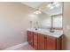 Well-lit bathroom featuring double sink vanity, large mirror, tile flooring, and shower with glass block window at 168 Melody Ln, Cameron, NC 28326
