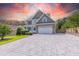 Charming two-story home with stone accents, spacious driveway and a manicured lawn under a vibrant sunset at 168 Melody Ln, Cameron, NC 28326