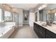 This bathroom features double sinks, dark cabinets, tiled flooring, and a soaking tub with shower at 17 Fountainhead Ln, Garner, NC 27529