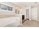 Bright bathroom featuring a large soaking tub, tile floors, and a neutral color palette at 1726 Rapids Ct, Franklinton, NC 27525