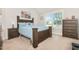 Cozy bedroom showcasing a wooden bed frame, matching dressers, and a bright window with neighborhood views at 1726 Rapids Ct, Franklinton, NC 27525