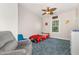 This bedroom features a car shaped bed, ceiling fan and a comfortable sitting chair on a carpeted floor at 1726 Rapids Ct, Franklinton, NC 27525