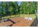 Large, wood deck features a lawn and treeline view, metal railing, and cornhole game at 1726 Rapids Ct, Franklinton, NC 27525