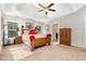 Bright main bedroom with ceiling fan, tray ceiling, walk-in closet, and ensuite bathroom at 1726 Rapids Ct, Franklinton, NC 27525
