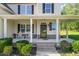 Inviting front porch with classic white rocking chairs and manicured landscaping at 1726 Rapids Ct, Franklinton, NC 27525