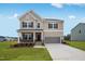 Inviting two-story home with stone accents, a covered porch, and a spacious two-car garage at 182 E Fountainhead Ln, Garner, NC 27529