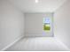 Minimalist bedroom features neutral decor, plush carpeting, and plenty of natural light at 182 E Fountainhead Ln, Garner, NC 27529