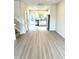 Open-concept layout with sleek floors leading to the kitchen with stainless steel appliances at 189 Seville Way, Clayton, NC 27520