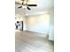 Open-concept living room with modern ceiling fan and sleek flooring adjoining kitchen at 189 Seville Way, Clayton, NC 27520