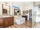 Luxurious primary bathroom with a freestanding tub, dual vanities, decorative mirrors, and a glass-enclosed shower at 190 Mitchells Chapel Road, Pittsboro, NC 27312
