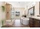 Bright bathroom featuring a soaking tub, glass shower, and double vanities at 190 Mitchells Chapel Road, Pittsboro, NC 27312