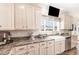 Well-lit kitchen with granite countertops, a farmhouse sink, modern appliances, and plenty of storage at 190 Mitchells Chapel Road, Pittsboro, NC 27312