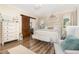 Inviting main bedroom with a crystal chandelier, barn door access to a primary bathroom, and lots of natural light at 190 Mitchells Chapel Road, Pittsboro, NC 27312