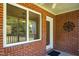 Covered porch with brick facade, large window, white trim, and an adjacent door at 1975 Oakridge Duncan Rd, Fuquay Varina, NC 27526
