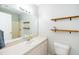 Bathroom features a white vanity, sink, toilet, and shower with wood shelving at 1975 Oakridge Duncan Rd, Fuquay Varina, NC 27526