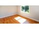 Bedroom features hardwood floors, light walls, white trim, and a bright window at 1975 Oakridge Duncan Rd, Fuquay Varina, NC 27526